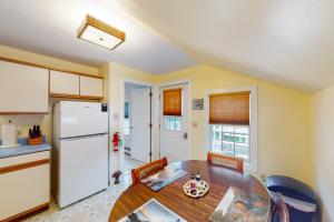 a kitchen with a table and a white refrigerator at Harbor Haven in Bass Harbor