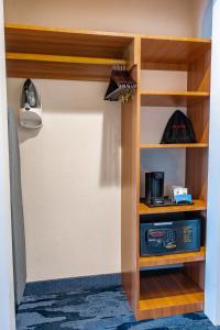 a room with a closet with wooden shelves and a microwave at Fairfield Inn by Marriott JFK Airport in Queens