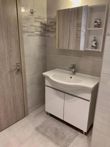 Lýria Boutique Apartments في ليغيا: حمام أبيض مع حوض ومرآة