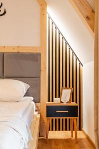ein Schlafzimmer mit einem Bett mit einem Bettrahmen aus Holz in der Unterkunft Olczańska Kotlina Apart&Room in Zakopane