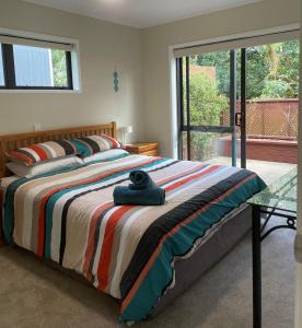een slaapkamer met een bed met een kleurrijke deken bij Baybell Lodge in Tauranga