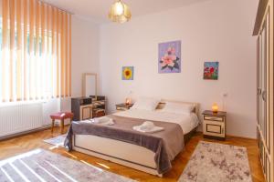ブラショヴにあるBarok Apartmentsのベッドルーム1室(大型ベッド1台、テーブル2台付)