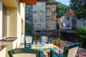 a table and chairs on a balcony with a clock at Barok Apartments in Braşov