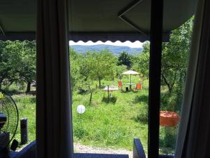 ein Fenster mit Blick auf einen Garten mit einem Tisch und Stühlen in der Unterkunft Glamping pe Drum Transfagarasan srl in Curtea de Argeş