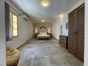 een grote kamer met een slaapkamer met een bed en een raam bij Archipelagos Boutique Hotel in Skhoinoussa