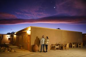 Un uomo e una donna in piedi davanti a un palazzo di Hotel Don Raul a San Pedro de Atacama