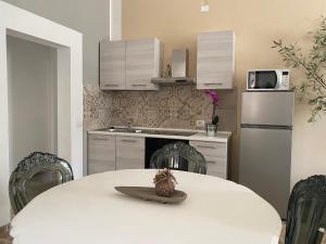 a kitchen with a white table and a white refrigerator at La Bellavista Decameron View in Certaldo