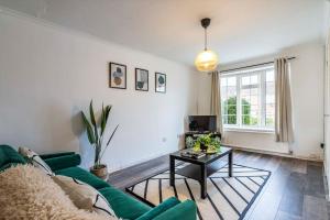 a living room with a green couch and a table at Cosy Home - Contractors Welcome - Garden & Free Parking in Derby