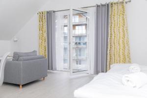 ein Schlafzimmer mit einem Bett, einem Stuhl und einem Fenster in der Unterkunft VacationClub - Stubai Apartament 38 in Heudorf