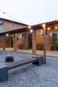 un patio con un banco de madera frente a un edificio en Pousada Vó Lete, en Penha