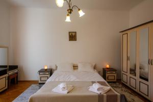 a bedroom with a bed with two towels on it at Barok Appart in Braşov