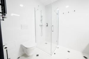 biała łazienka z prysznicem i toaletą w obiekcie VacationClub - Czarna Perła Apartament 303 w Stroniu Śląskim