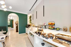 a store with green walls and a counter with food at Bloom Hotel in Ljubljana