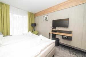 pokój hotelowy z 2 łóżkami i telewizorem z płaskim ekranem w obiekcie VacationClub - Czarna Perła Apartament 303 w Stroniu Śląskim