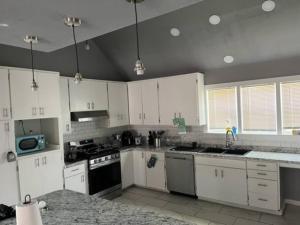 a kitchen with white cabinets and white appliances at Gilcrease Hillside in Tulsa