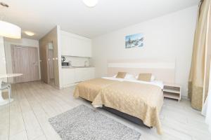 una camera bianca con letto e cucina di VacationClub - Solden Apartament 29 a Sienna
