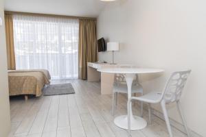 una camera d'albergo con letto, tavolo e sedie di VacationClub - Solden Apartament 29 a Sienna