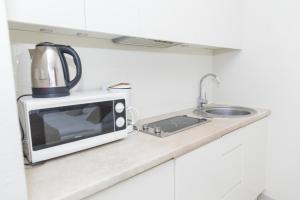 a microwave sitting on a counter next to a sink at VacationClub - Solden Apartament 29 in Sienna