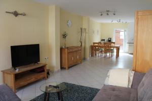 a living room with a couch and a flat screen tv at Gemütliches Apartment, nahe Wetzlar in Wetzlar