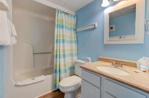 Un baño con lavabo, inodoro y ducha. en 0601 Seaclusion by Atlantic Towers, en Carolina Beach