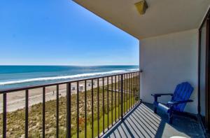 un balcón con una silla azul y la playa en 0601 Seaclusion by Atlantic Towers, en Carolina Beach