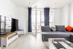 Stylish & Comfortable Top-Floor Flat in Harrow في لندن: غرفة معيشة مع أريكة وتلفزيون بشاشة مسطحة