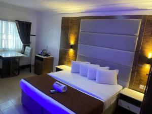 a hotel room with a large bed with a purple light at Presken Hotel @Villa in Ikeja