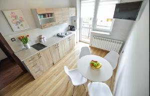 a kitchen with a white table and white chairs at Noclegi u Majki in Zator