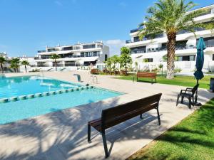 uma piscina com um banco ao lado de um edifício em London Beach Benidorm em Finestrat