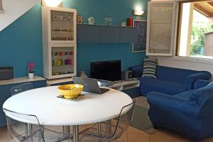 a living room with a white table and a blue wall at Villa con porticato sul prato in Isola Albarella