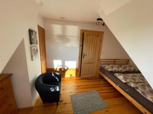 a room with a bed and a chair and a door at LaVendana in Rukławki +24 photos
