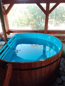 a hot tub in a wooden barrel with blue water at Casa Ispas in Râșca