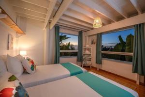 a bedroom with a bed and a large window at Arevareva Pole House Papeete in Papeete