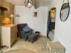 salon z krzesłem i lustrem w obiekcie Clos des Mages w mieście Le Beaucet