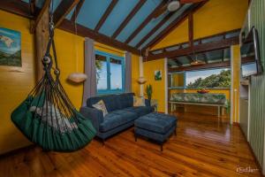 a living room with a couch and a hammock at Arevareva Pole House Papeete in Papeete