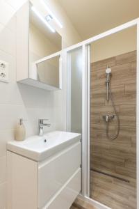 biała łazienka z umywalką i prysznicem w obiekcie Comfort Zone Apartment w Budapeszcie