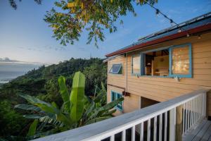 a house with a balcony with a view of the ocean at Arevareva Pole House Papeete in Papeete