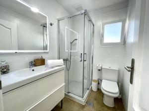 a white bathroom with a shower and a toilet at Iris Apartamento in Arrieta