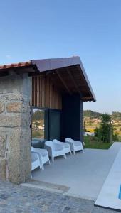 a group of white chairs sitting outside of a building at CASA DAS QUINTÃES in Figueiredo