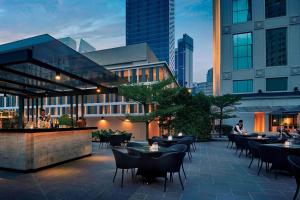 a rooftop patio with tables and chairs and buildings at JW Marriott Kuala Lumpur in Kuala Lumpur