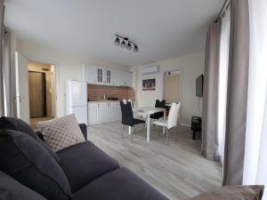 un soggiorno con divano e tavolo con sedie di Апартамент Орех А30 a Varna