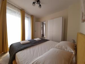 a bedroom with a large bed and a window at Апартамент Орех А30 in Varna City