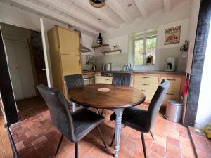 uma cozinha com uma mesa de madeira e cadeiras em Le nid Mésange em Alligny-en-Morvan