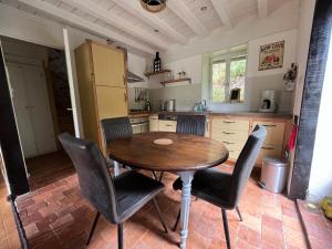 a kitchen with a wooden table and chairs at Le nid Mésange in Alligny-en-Morvan