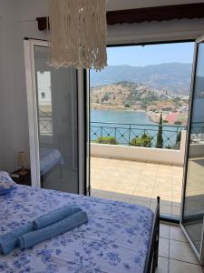 Schlafzimmer mit einem Bett und Blick auf das Wasser in der Unterkunft The view in Poros