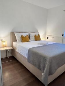a bedroom with a large white bed with yellow pillows at Lirica in Nerežišće