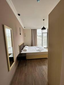 a bedroom with a bed and a mirror on the wall at Family Corner in K'obulet'i +18 photos