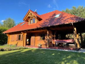 a large wooden house with a red roof at LaVendana in Rukławki