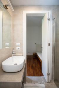 a bathroom with a white sink and a tub at Domus Cordara - Splendido appartamento nel verde in Rome