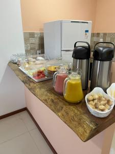 a kitchen counter with food and drinks on it at Hostel Flor de Ipê in Barreirinhas